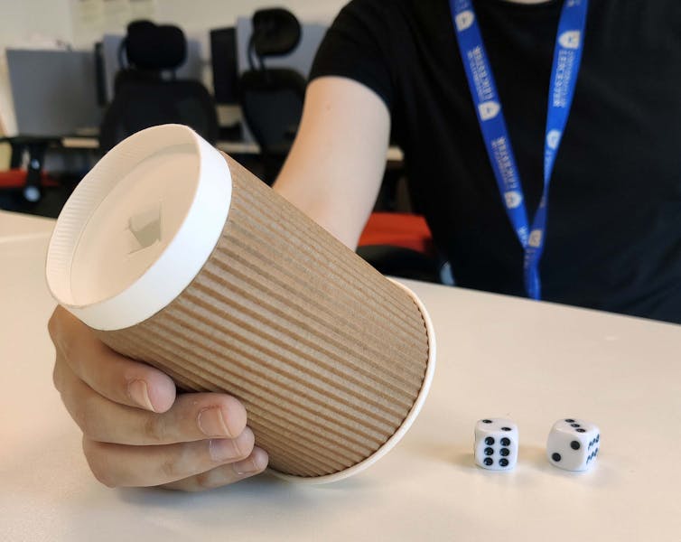 Image of a cup and two dice.
