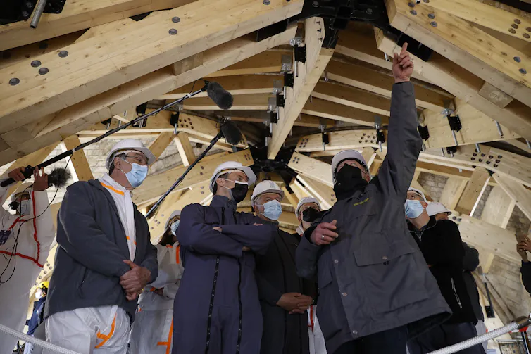 Emmanuel Macron et les responsables de la reconstruction de Notre-Dame dans les combles de la cathédrale