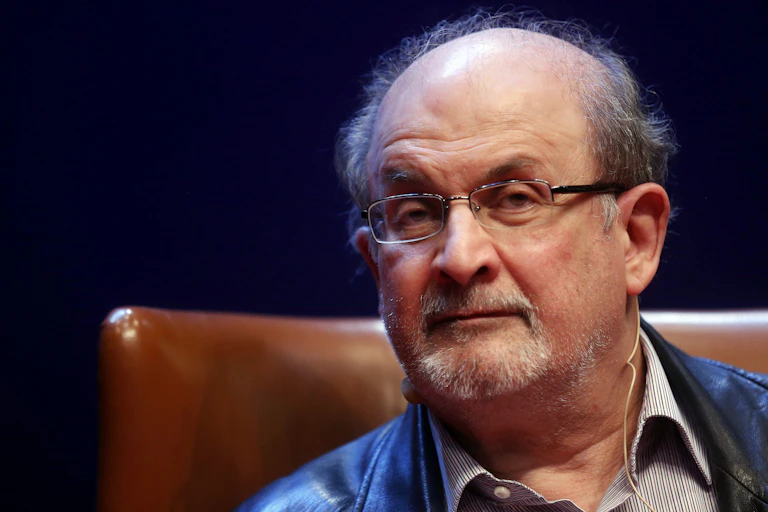 Close-up photo of Salman Rushdie sitting in a leather chair