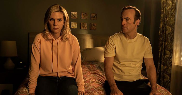 The characters Kim Wexler and Jimmy McGill sit on a bed.