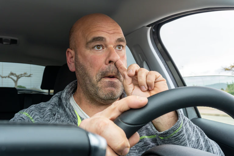 homme se fouille dans le nez au volant de sa voiture