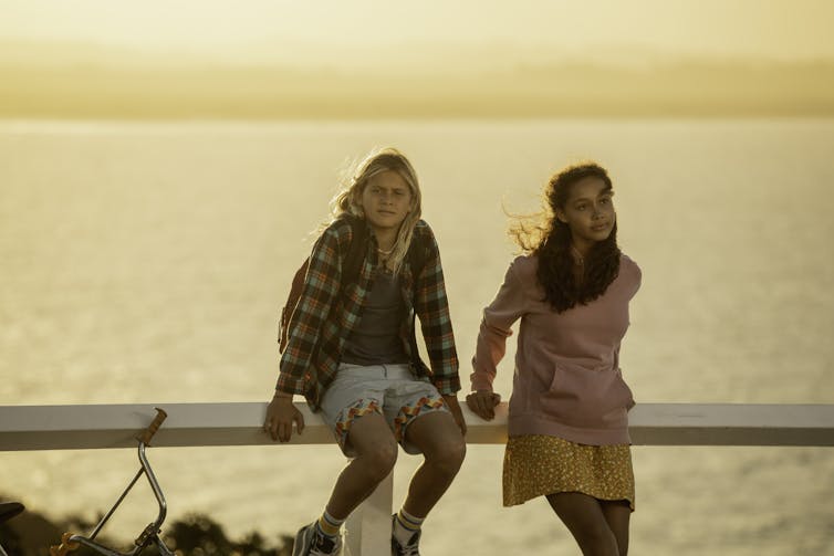 A boy and girl under a sunset.