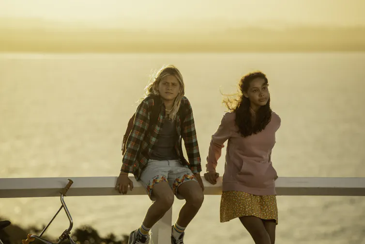 A boy and girl under a sunset.