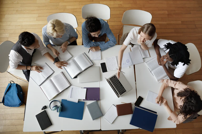 Students seen sitting around a table.