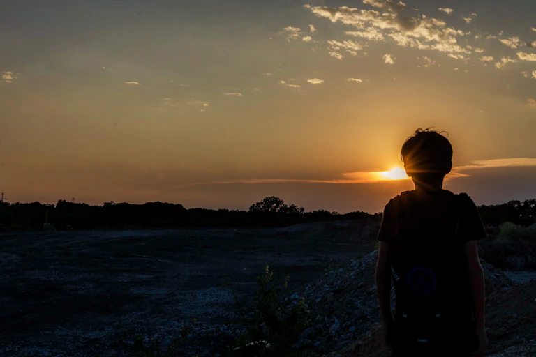 Child silhouetted against twilit background
