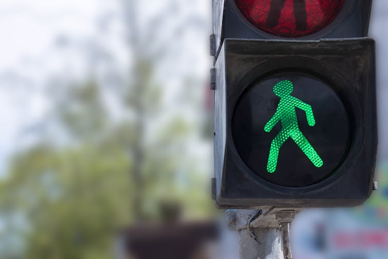 A close-up photo of a green walk signal on a traffic light.