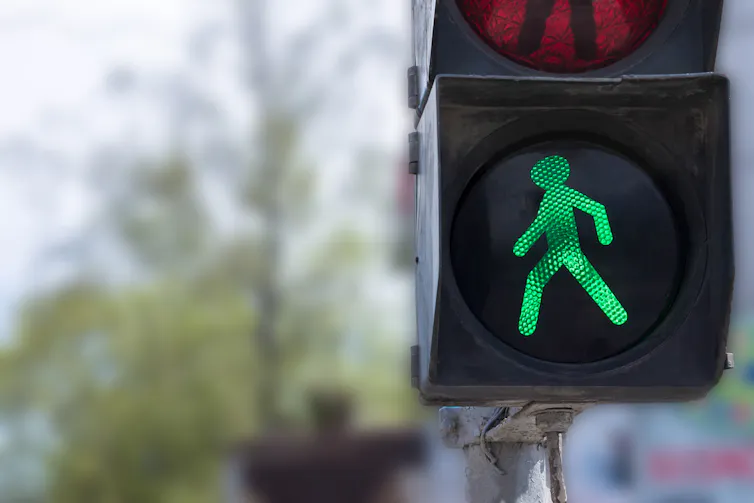 A close-up photo of a green walk signal on a traffic light.