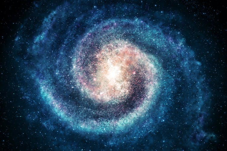 A glowing image of a spiral galaxy with blue arms and pale golden centre