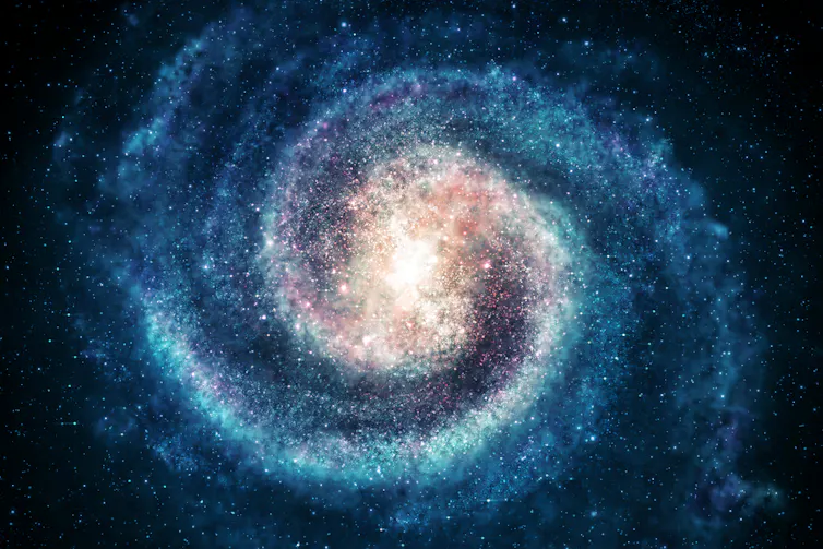 A glowing image of a spiral galaxy with blue arms and pale golden centre
