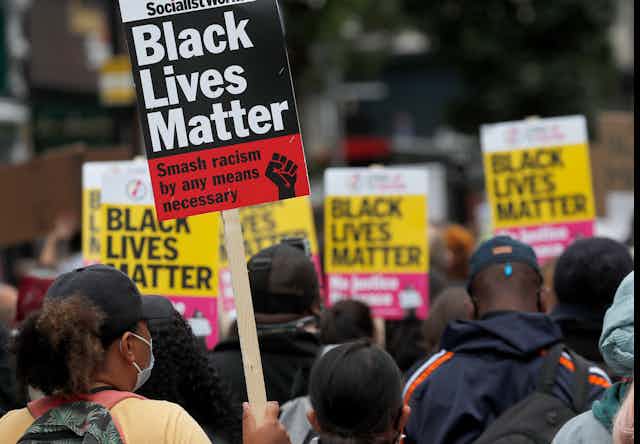 people at a protest holding signs that read BLACK LIVES MATTER
