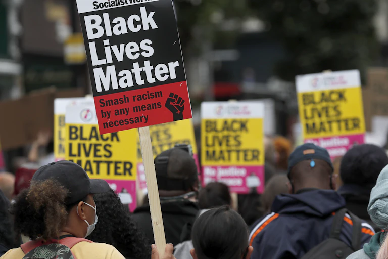 people at a protest holding signs that read BLACK LIVES MATTER