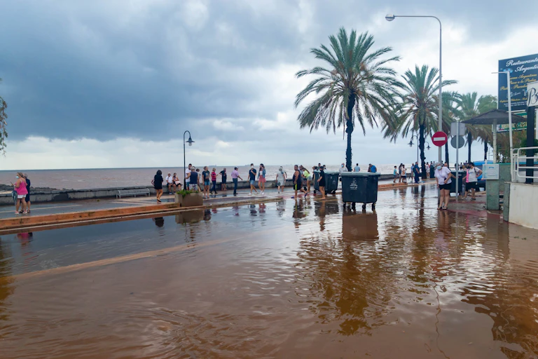 Paseo marítimo inundado bajo un cielo nublado.