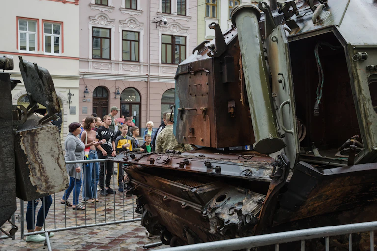 A mangled rank inside a barrier being looked at by a small crowd of people.
