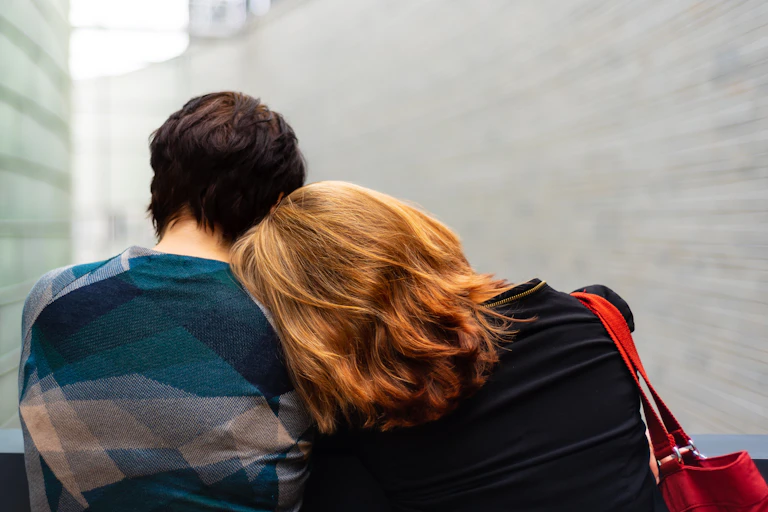 Woman puts her head on her partner's shoulder