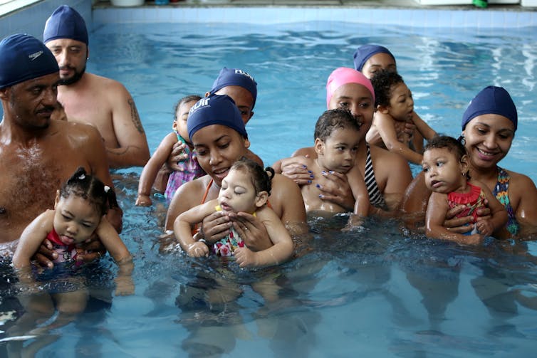parent and children working out in swimming pool