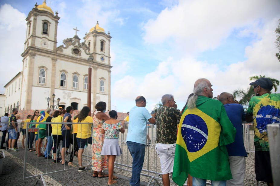People wearing yellow and green stand outside a Brazilian church.