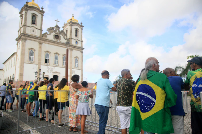 People wearing yellow and green stand outside a Brazilian church.