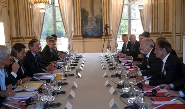 Group of politicians and economists sitting at a long table