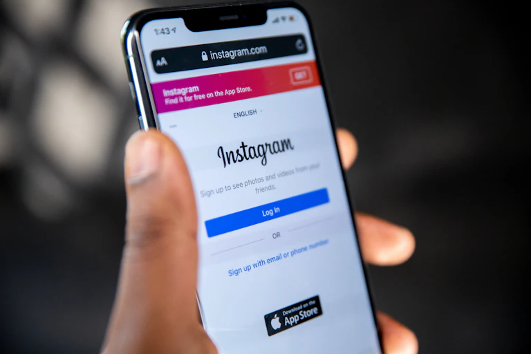 A photo of someone holding a cellphone with the instagram login screen displayed