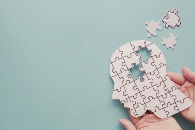 A jigsaw puzzle in the shape of a head, with some pieces missing.