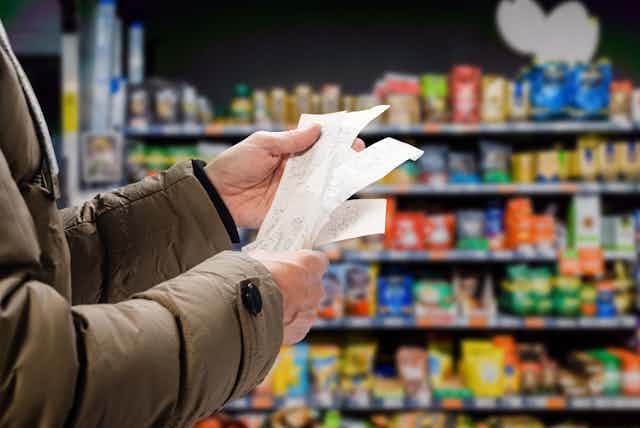 A man looking at a receipt in a grocery store