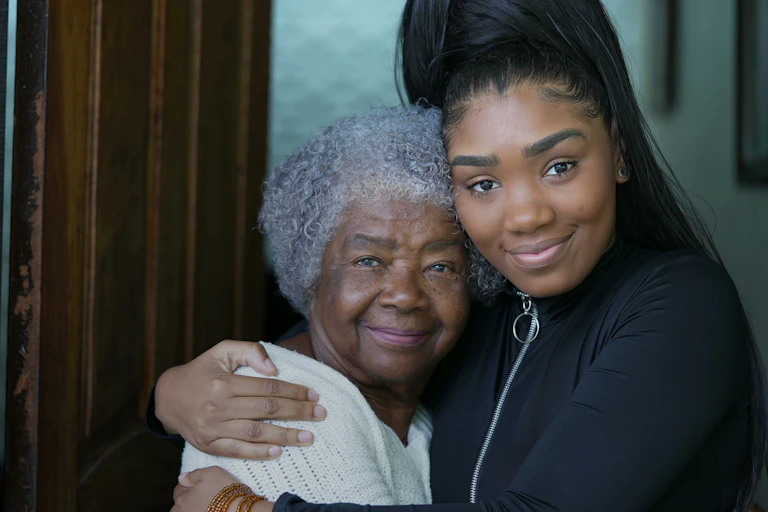 A young woman embracing an elder.