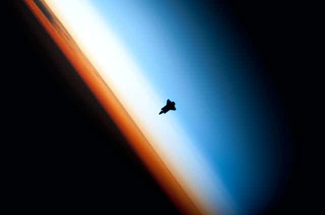 silhouette of a rocket heading toward a horizon