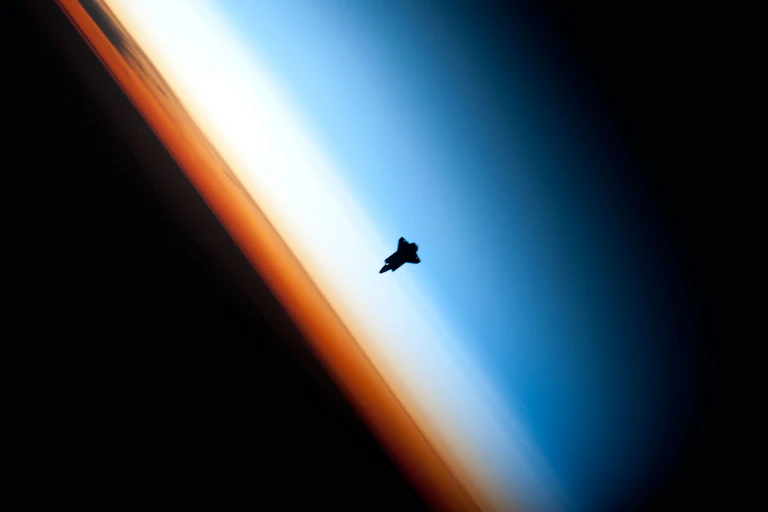 silhouette of a rocket heading toward a horizon