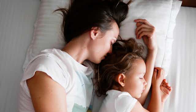 Mother co-sleeping with her young daughter.