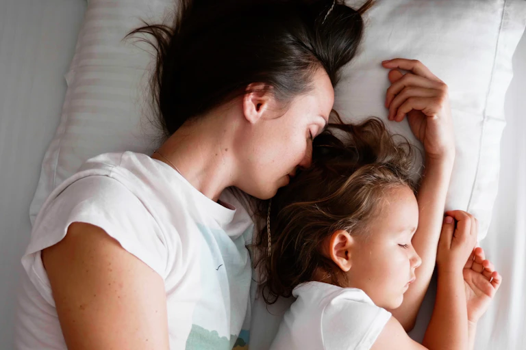 Mother co-sleeping with her young daughter.