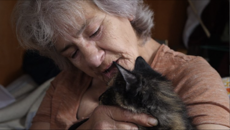 Older woman cuddles a cat