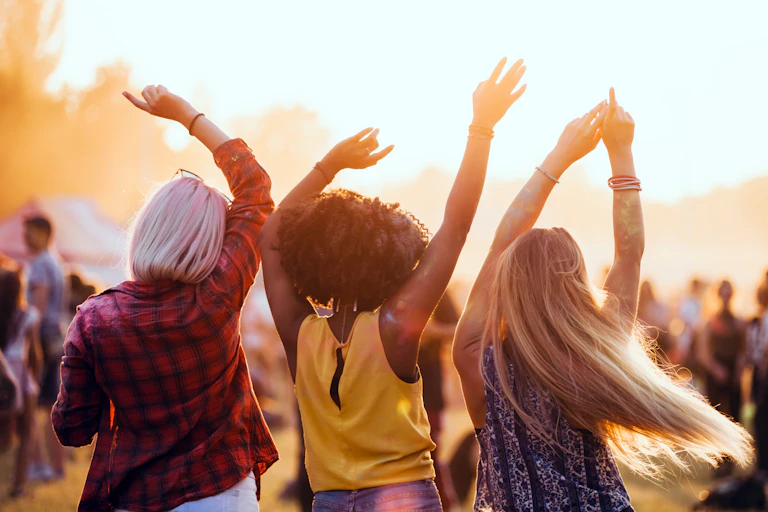 Three friends enjoying a music festival.