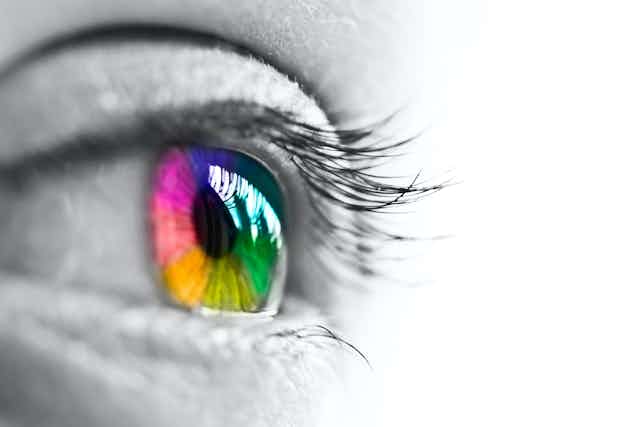 Imagen en blanco y negro de un ojo con el iris de colores.