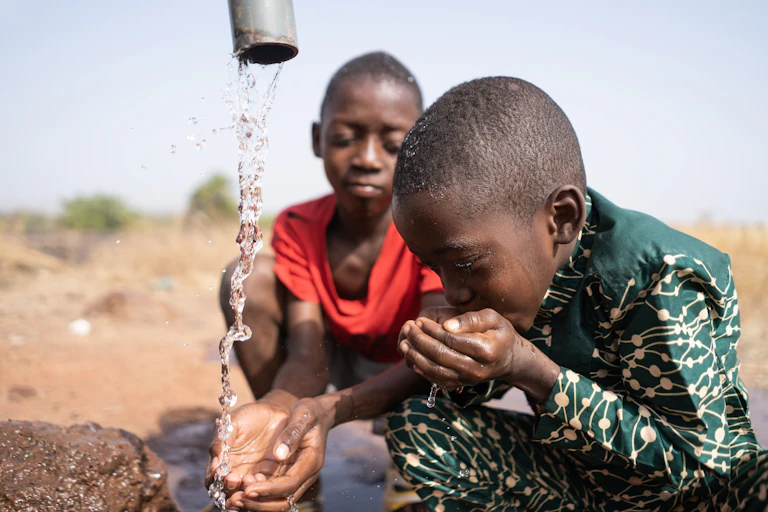 children drinking from a tap