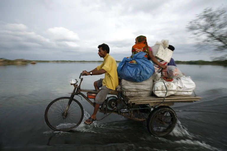 Two people on motorcycle cart with large bags