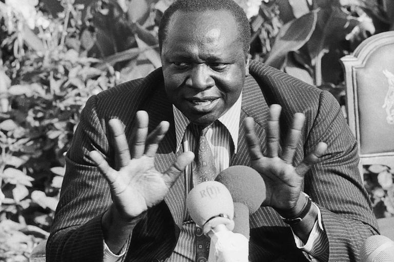Man seating while speaking into microphone.