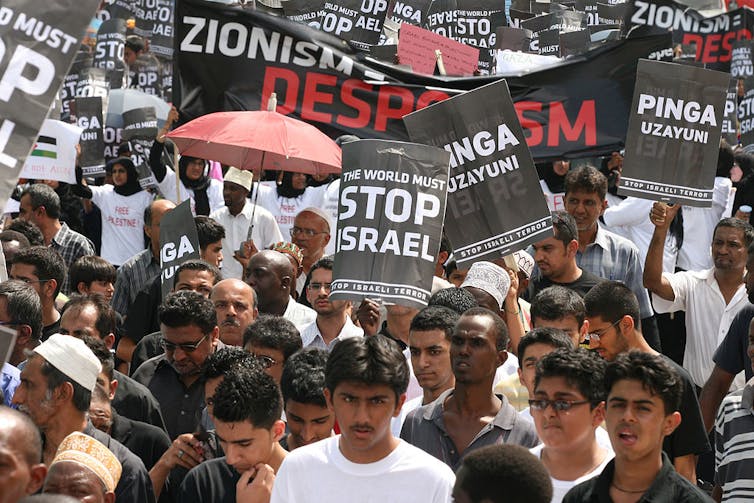 Hombres marchan con pancartas de 'stop Israel'.