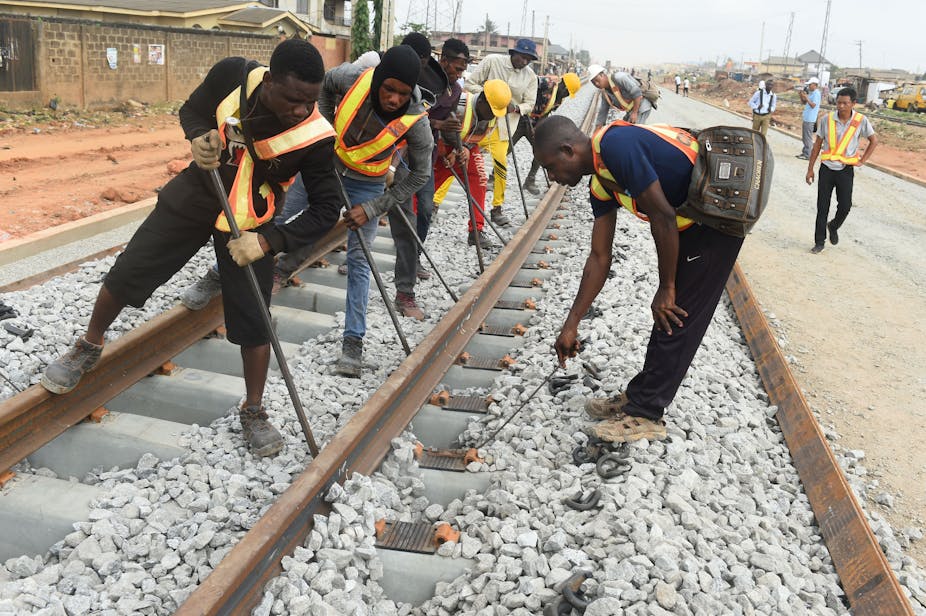 Men in reflective jackets, working on a new standard gauge railway line under construction in Lagos. 