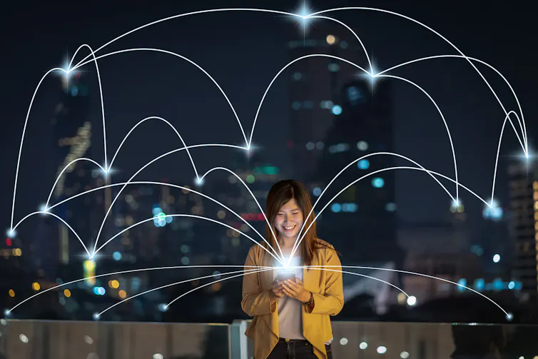 Woman with smartphone emitting a 'network' in background.