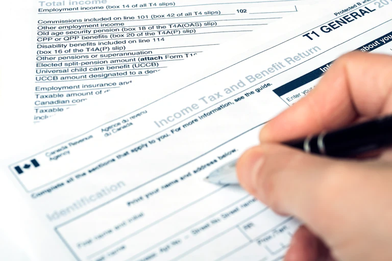 A hand filling out a Canadian income tax form