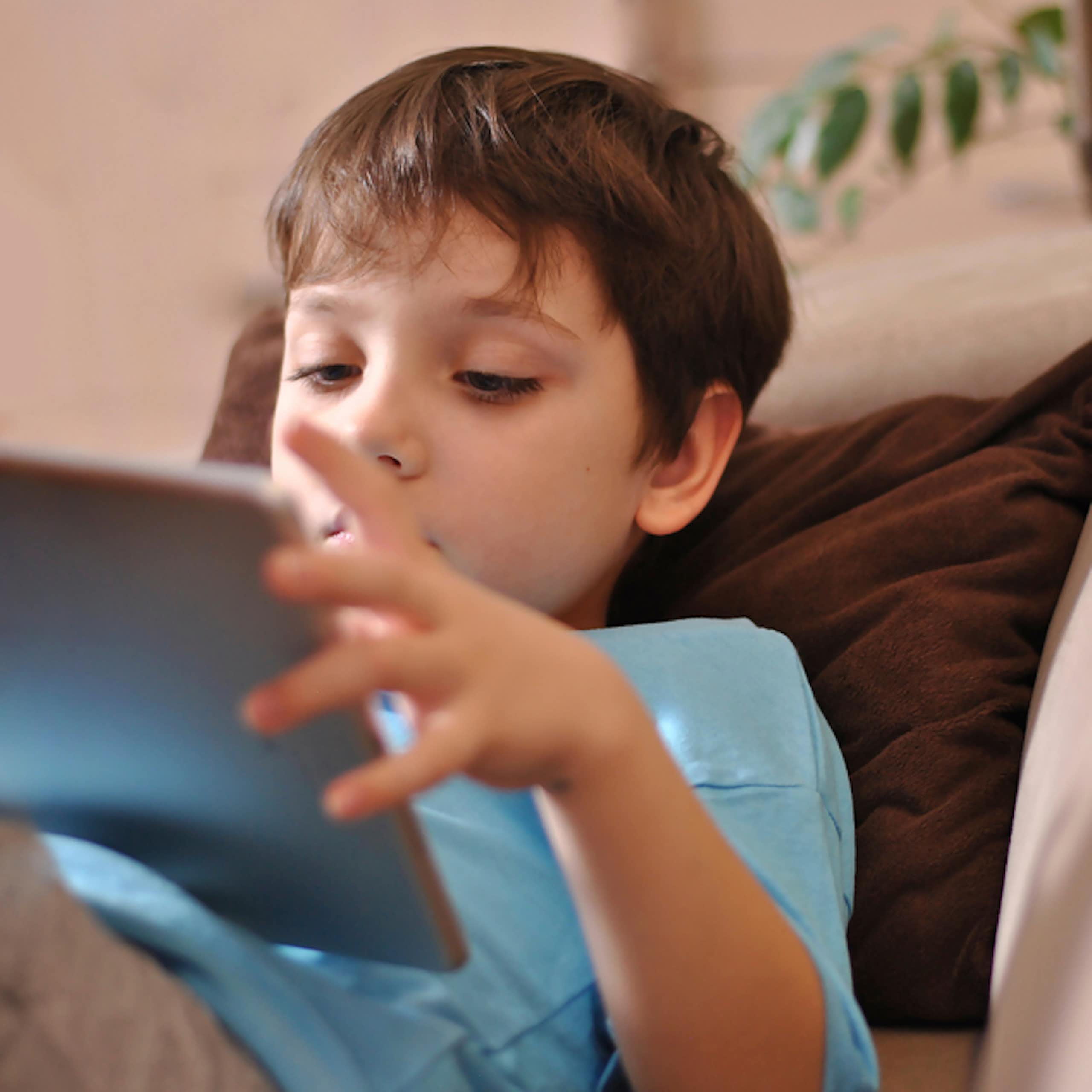 jeune garçon lit sur une tablette