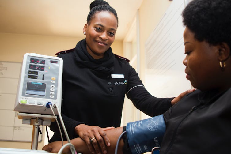 Nurse takes a woman's blood pressure