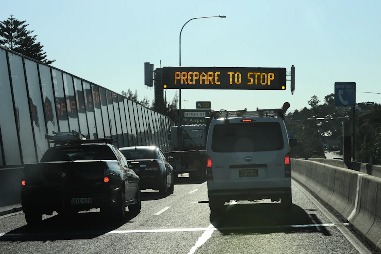 traffic queues in front of "prepare to stop" sign