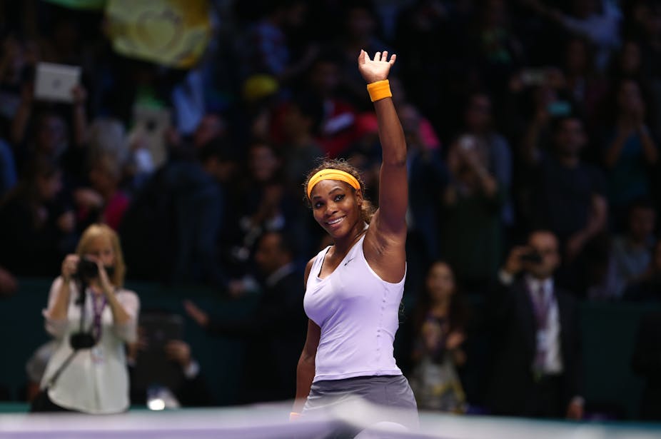 A picture of Serena Williams smiling and waving to the crowd during a tennis match.