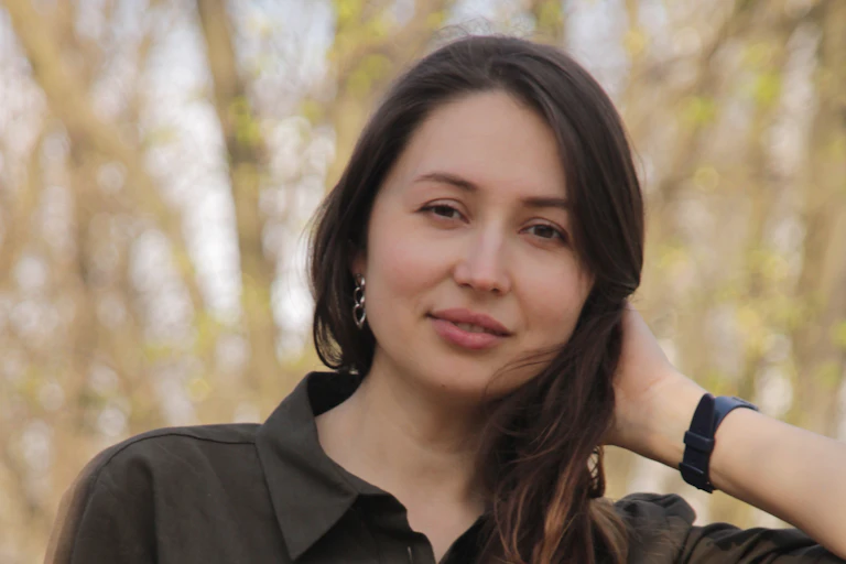 Une jeune femme prend la pose dans une rue.