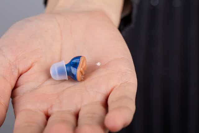Close up of hearing aid in a person's palm
