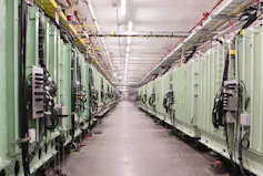 A hallway with dozens of large chambers on either side extending into the distance.