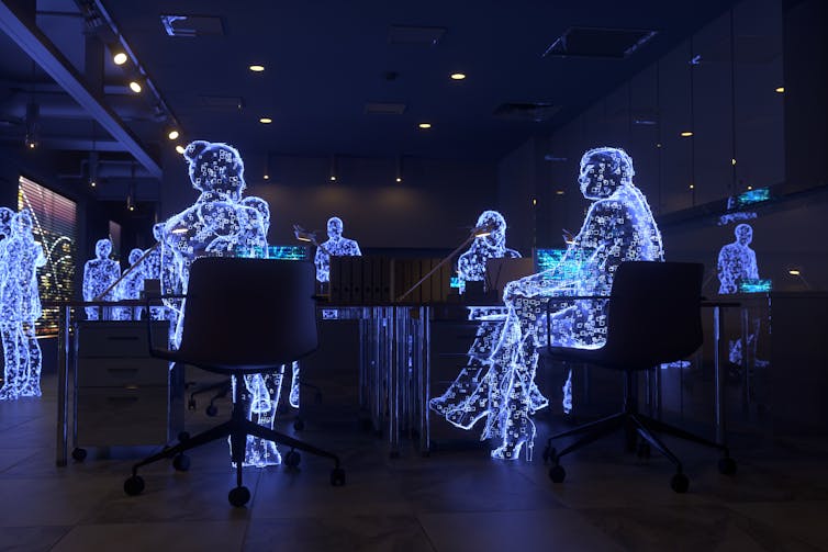 Futuristic outlines of people interact with one another in an office.