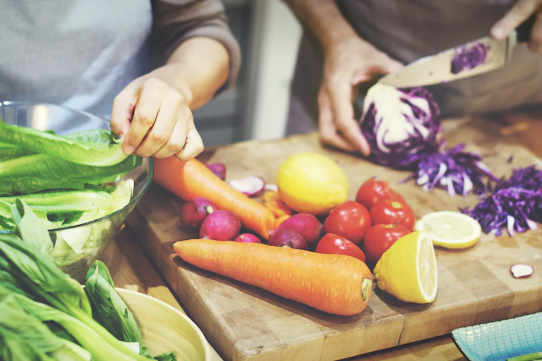 Two people chop vegetables