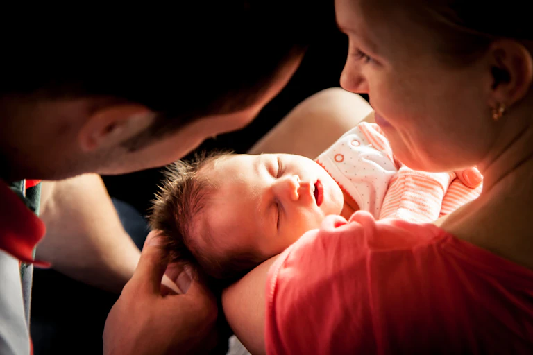 parents holding and looking at baby